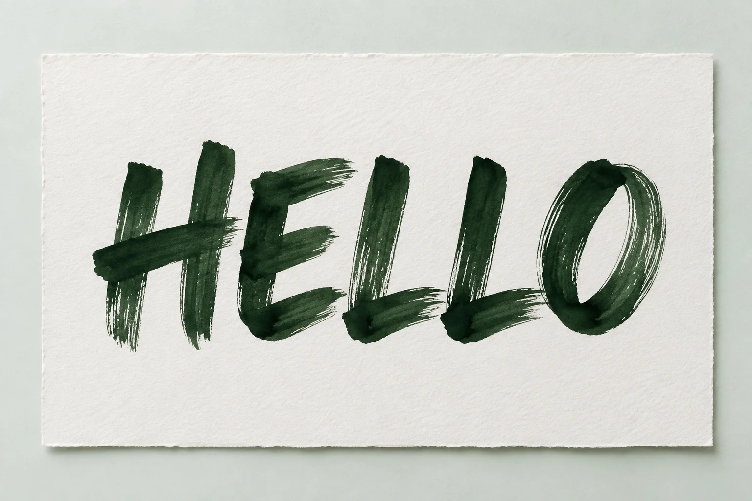 HELLO in bold hand-brushed forest-green ink on ivory paper